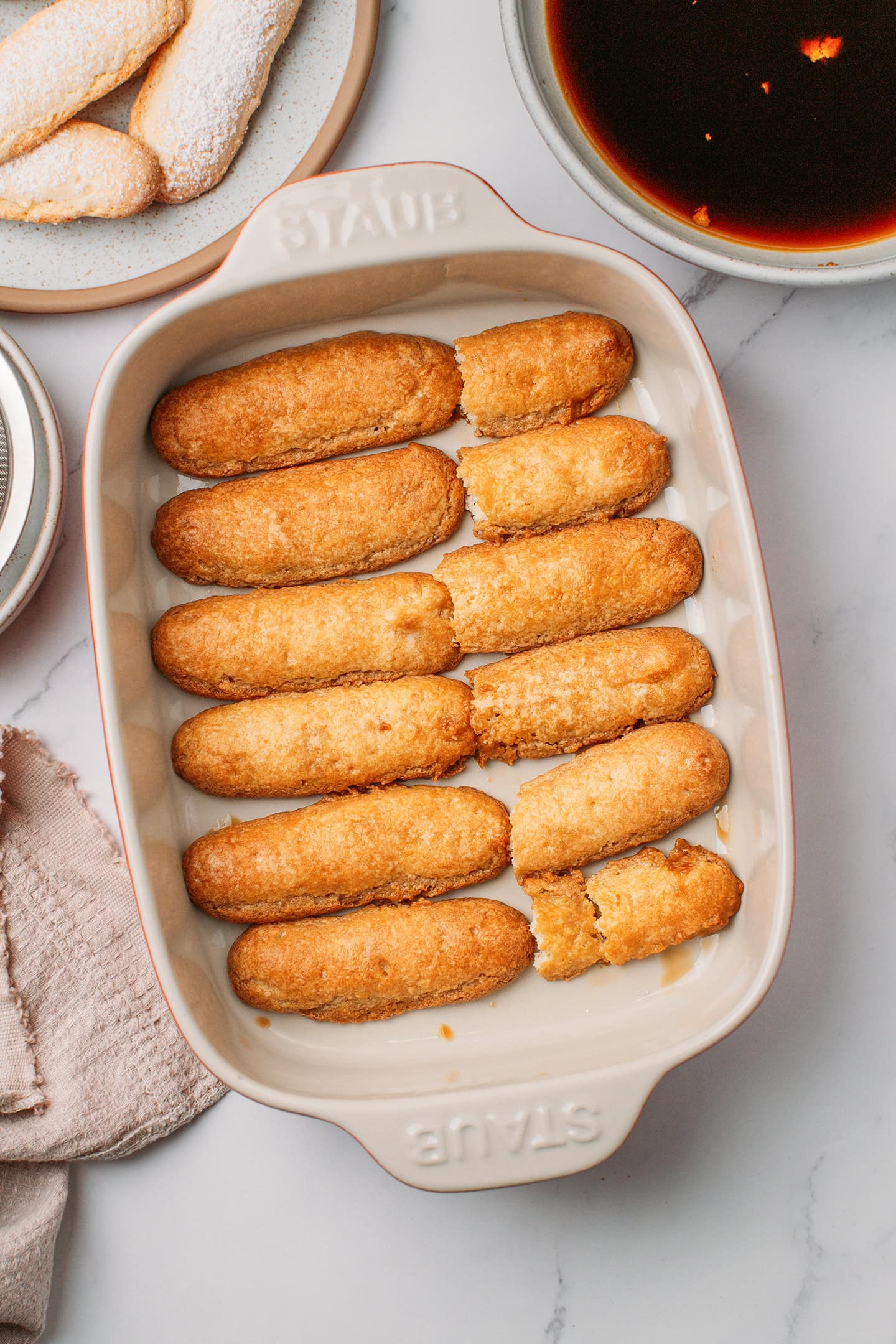 Ladyfingers arranged inside a baking dish.