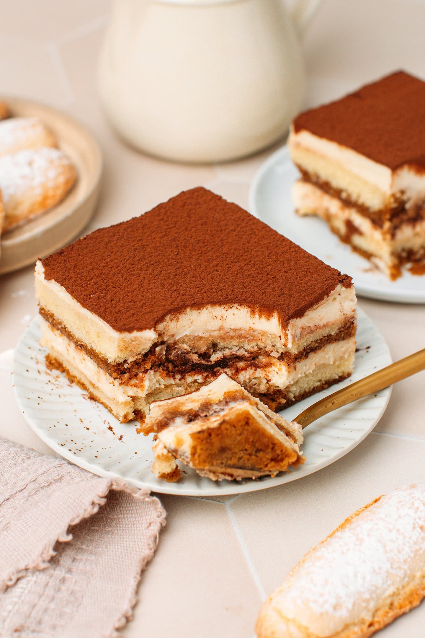 Sliced portion of vegan tiramisu on a small white plate.