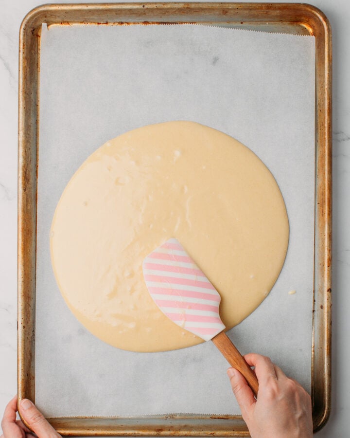 Spreading sponge cake batter on a baking sheet.