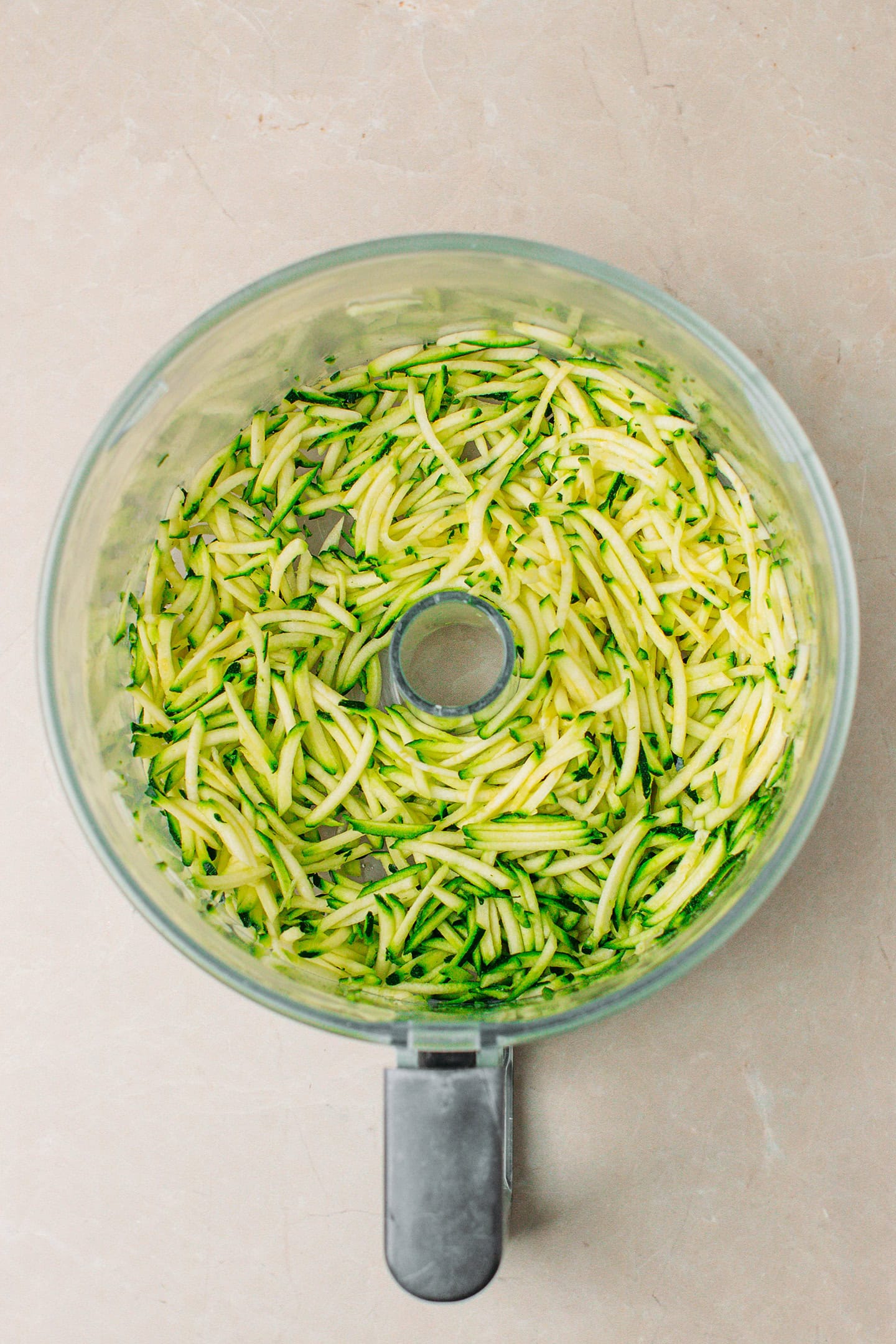 Grated zucchini in a food processor.
