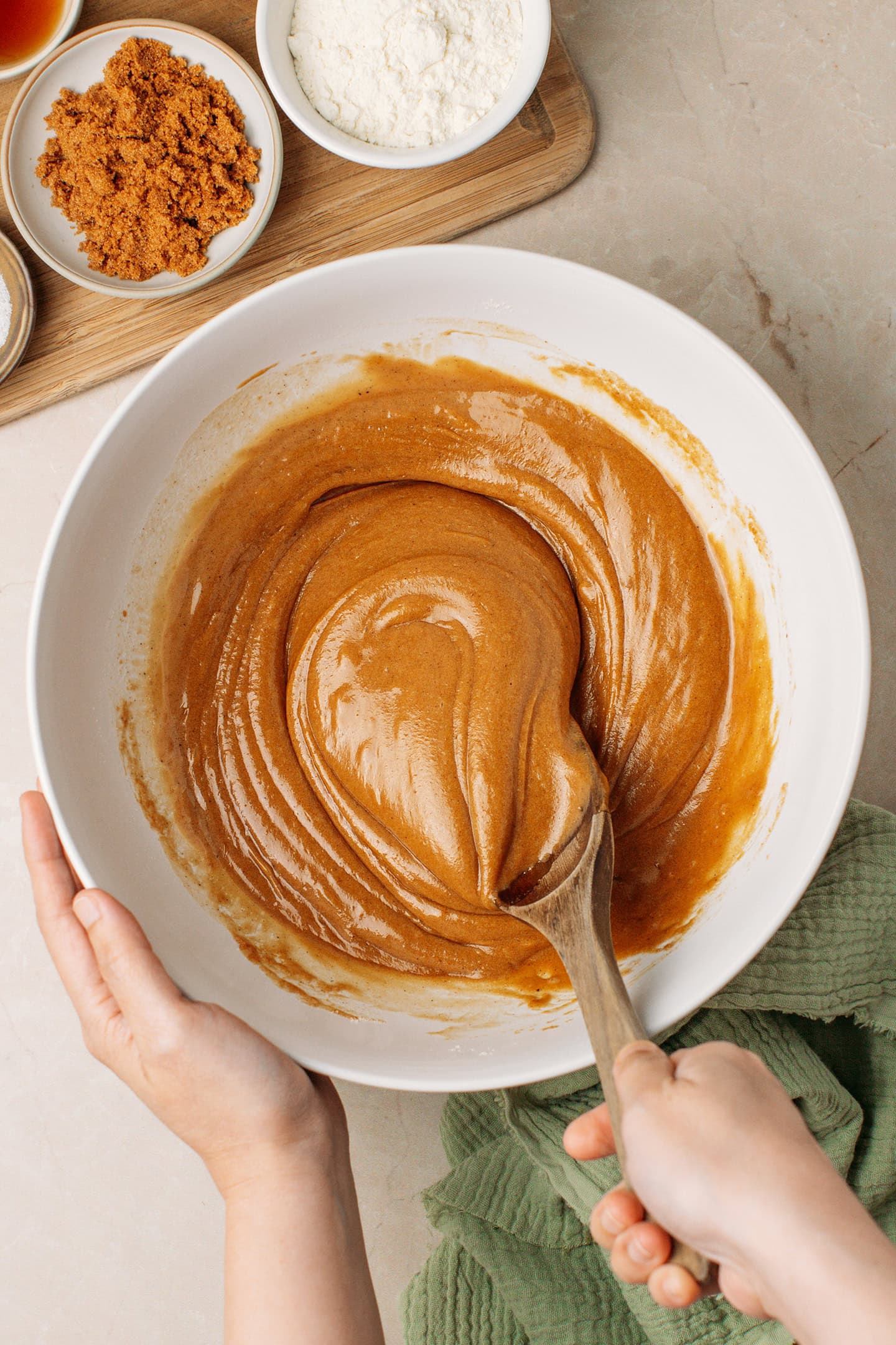 Mixing a brown cake batter in a mixing bowl.
