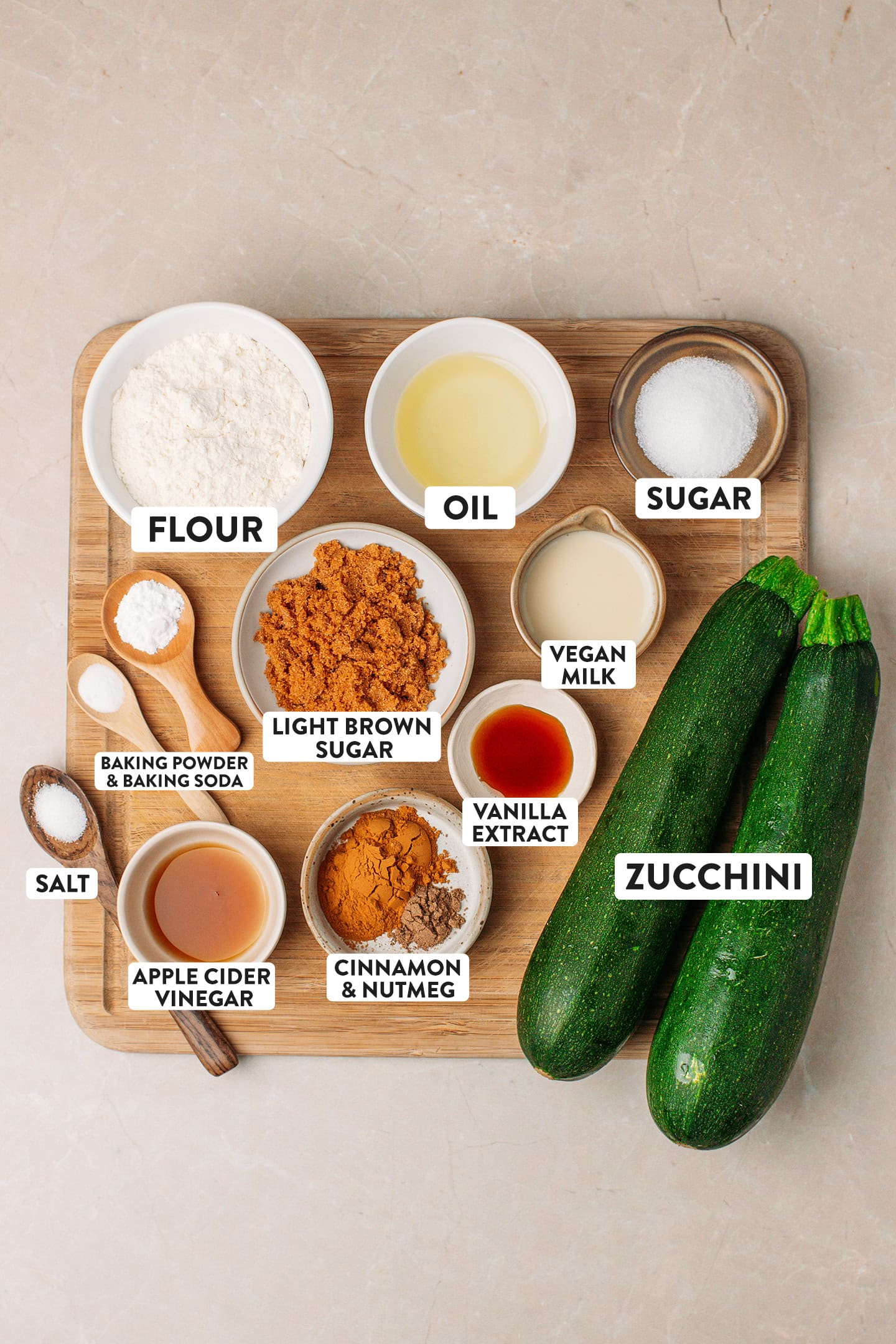 Ingredients like zucchini, flour, oil, sugar, light brown sugar, and spices.