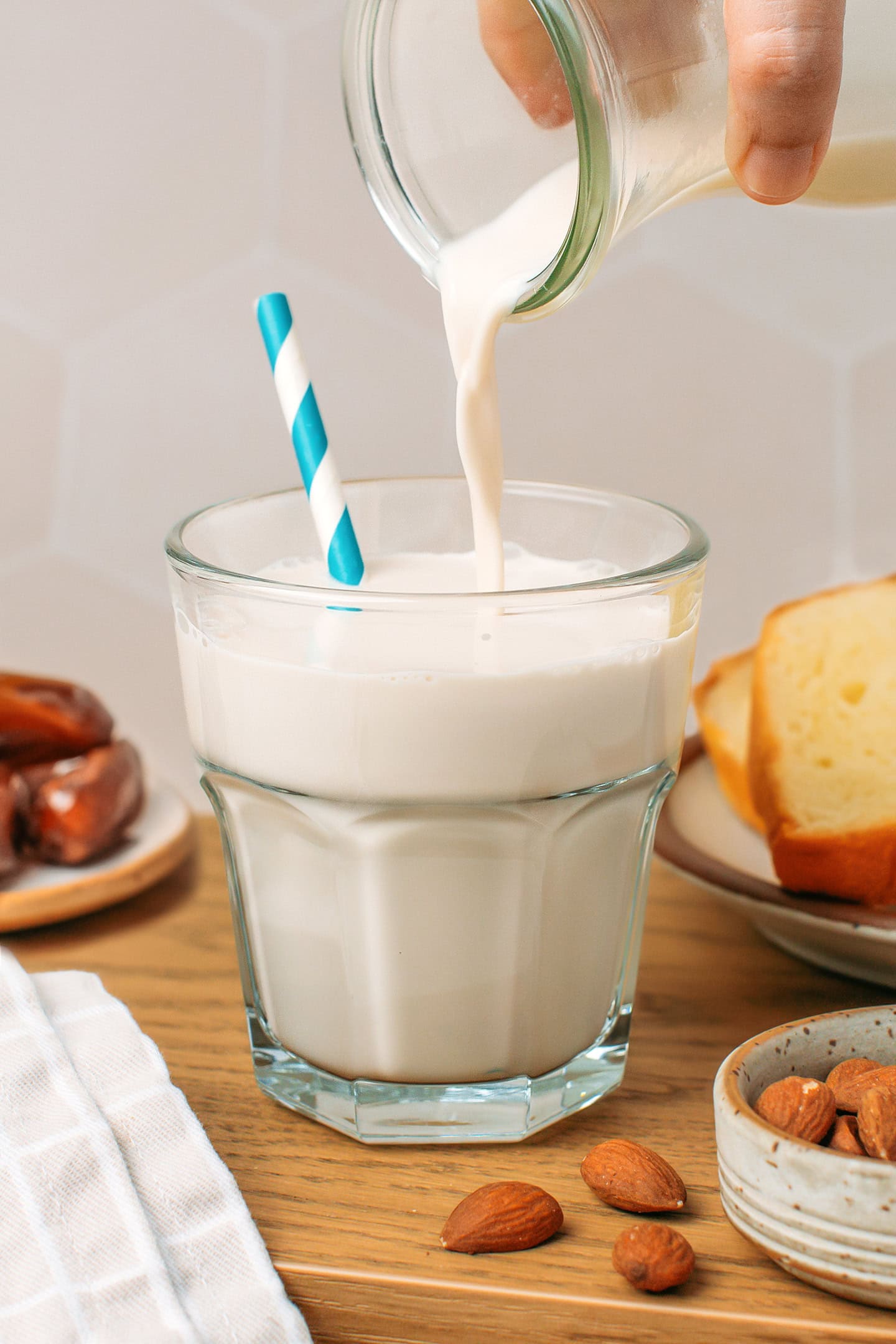 Pouring fresh almond milk into a glass.