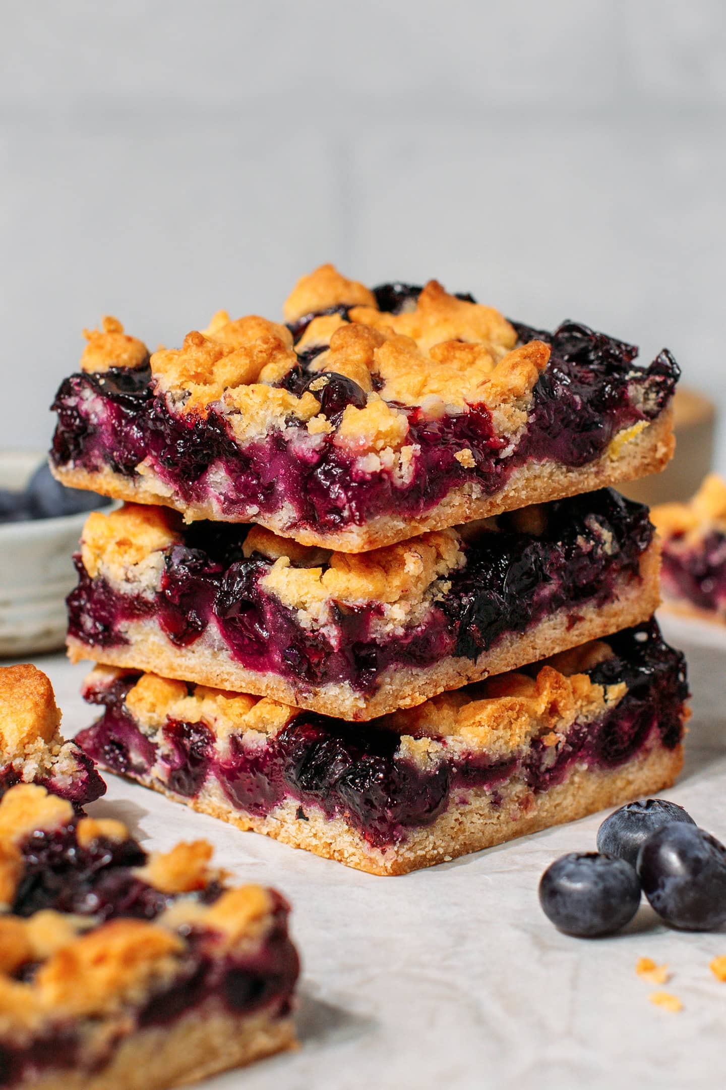 Three stacked blueberry crumble bars with a jammy blueberry filling.