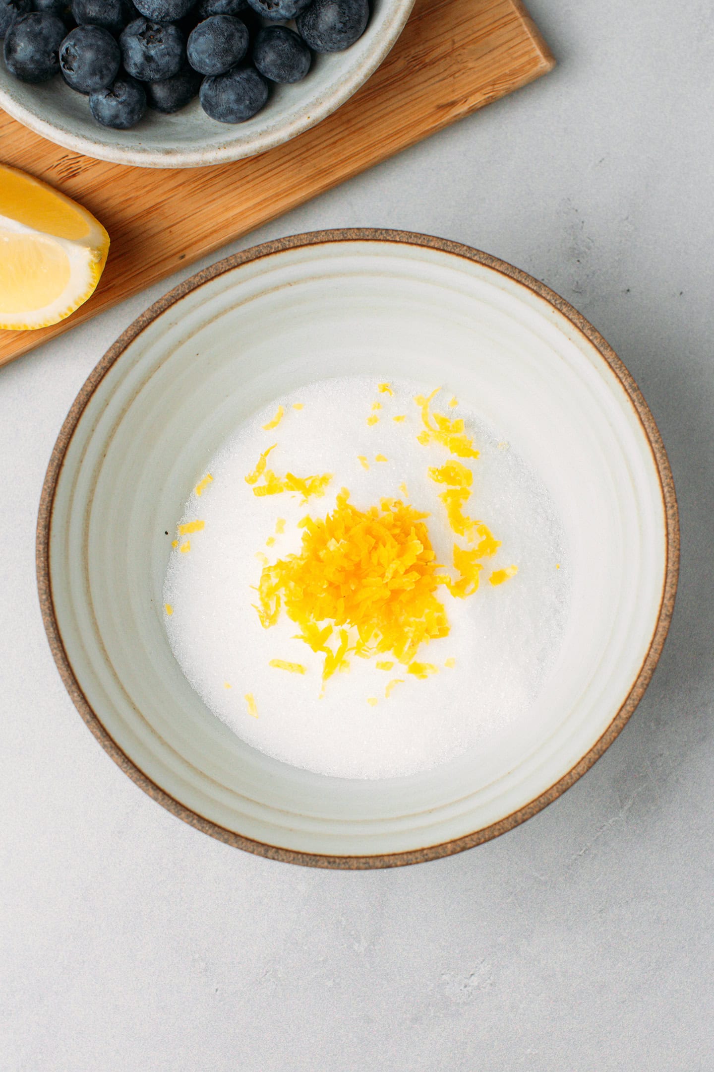 Sugar and lemon zest in a small bowl.