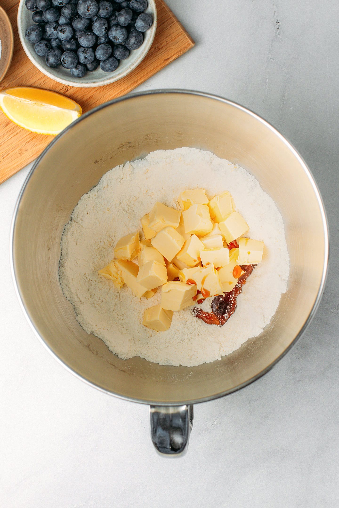 Flour, diced butter, and vanilla extract, in a stand mixer bowl.
