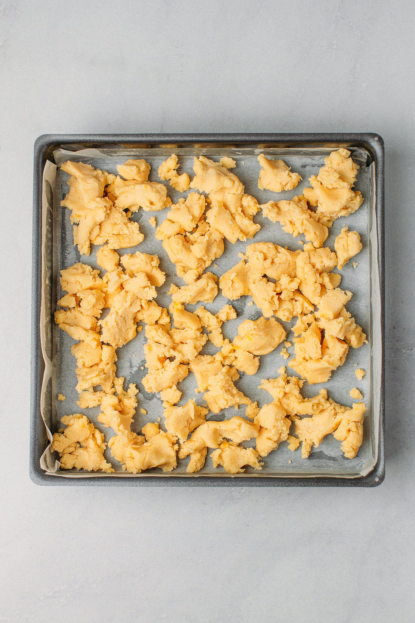 Shortbread dough in a square baking pan.