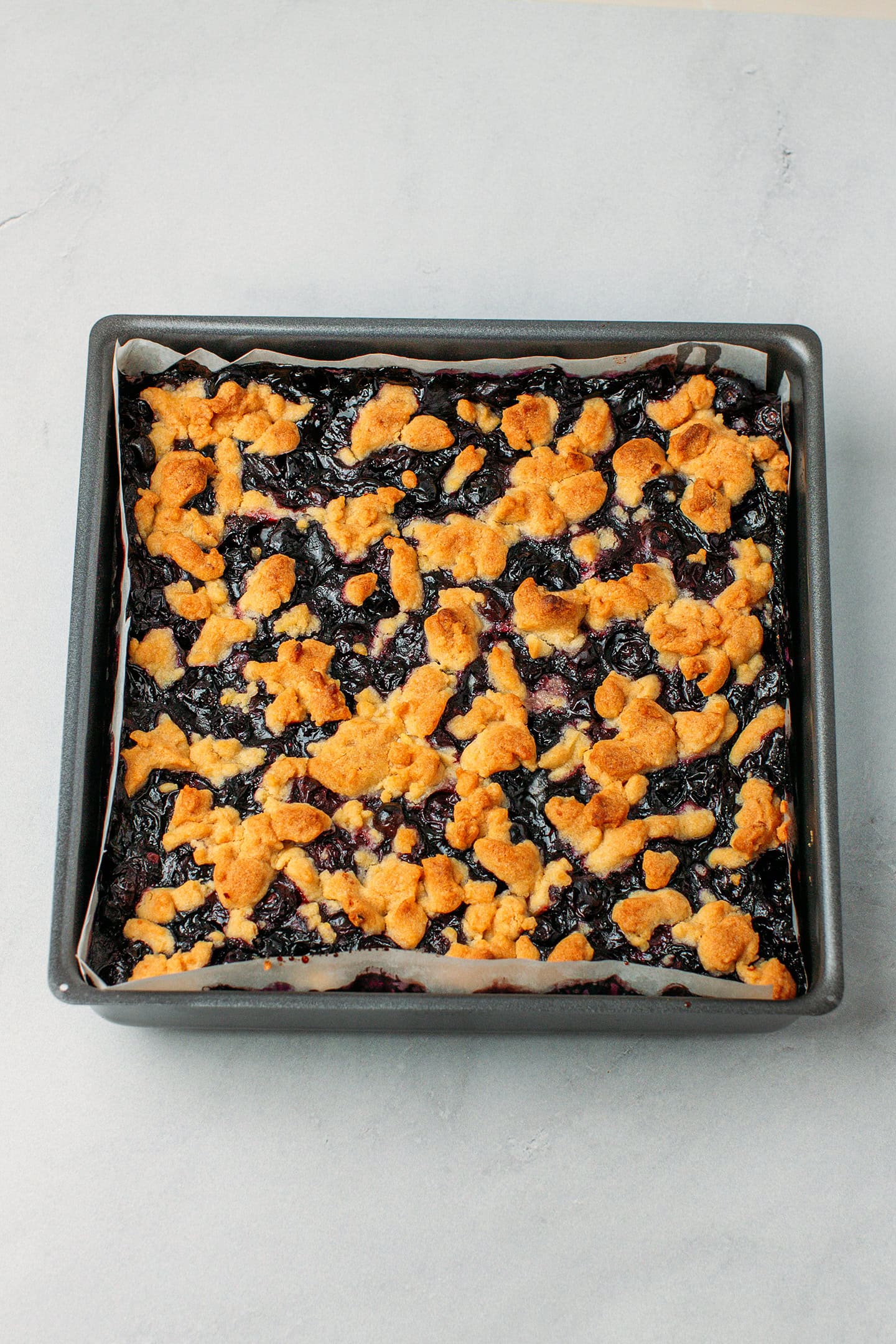 Baked blueberry crumble in a baking pan.