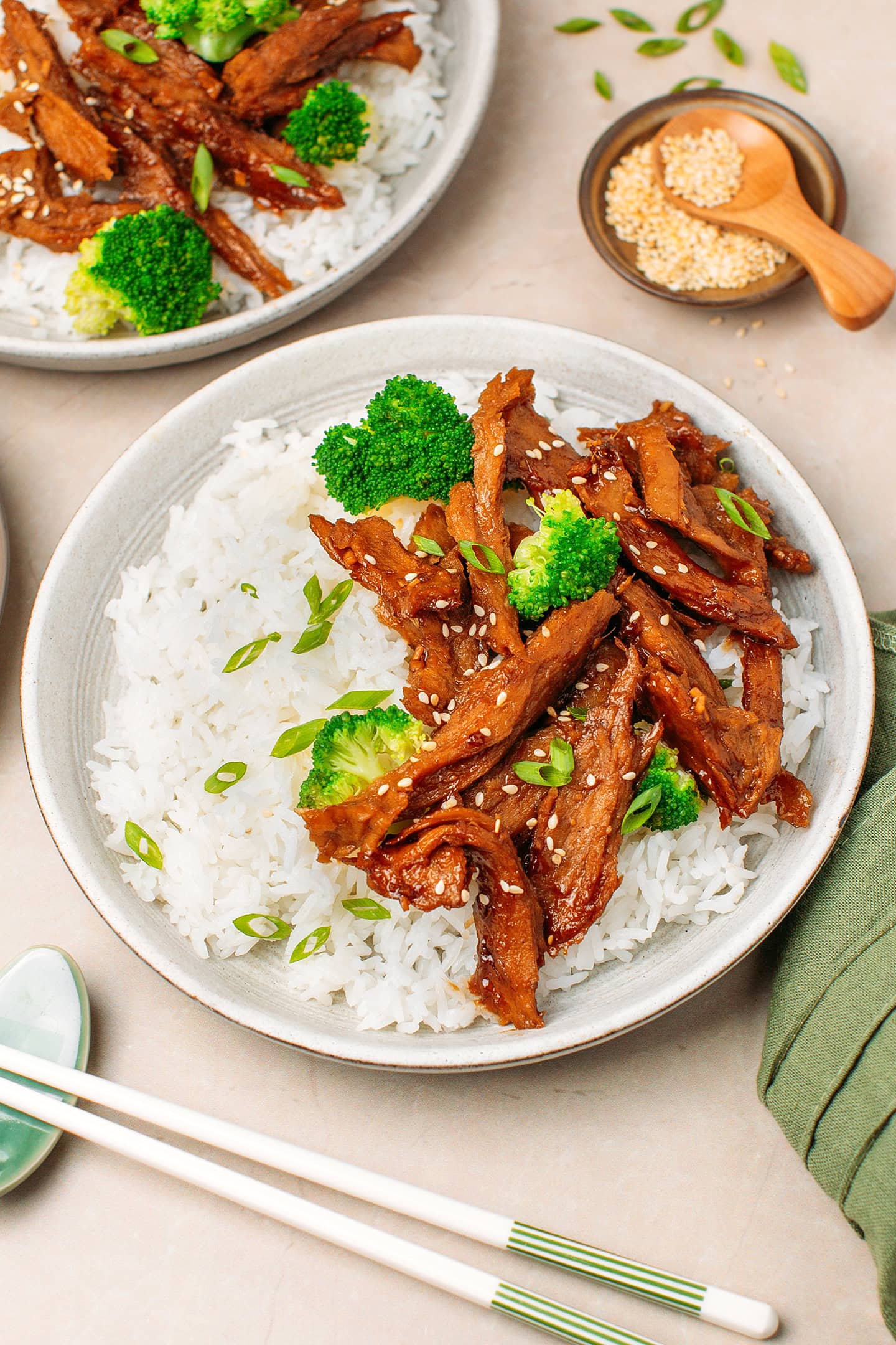 Plate filled with white rice, broccoli, and vegan teriyaki chicken strips.