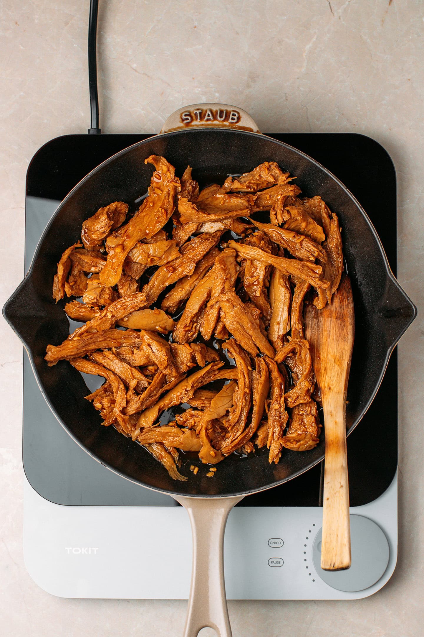 Vegan marinated chicken strips in a skillet.