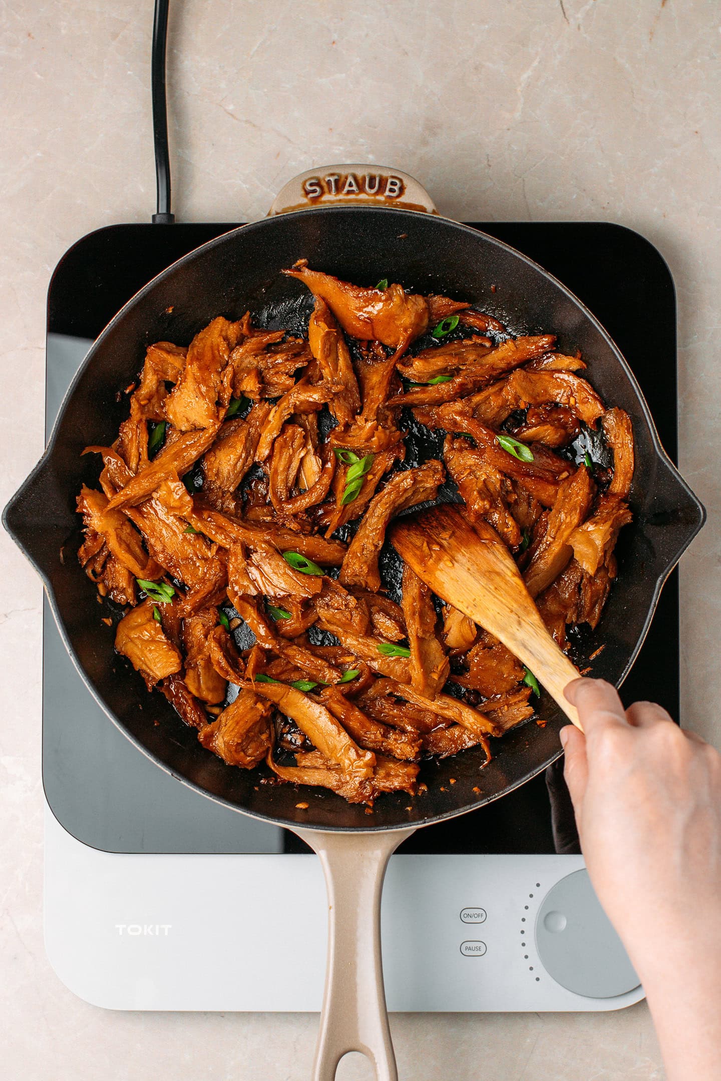 Sautéed vegan teriyaki chicken strips in a skillet.