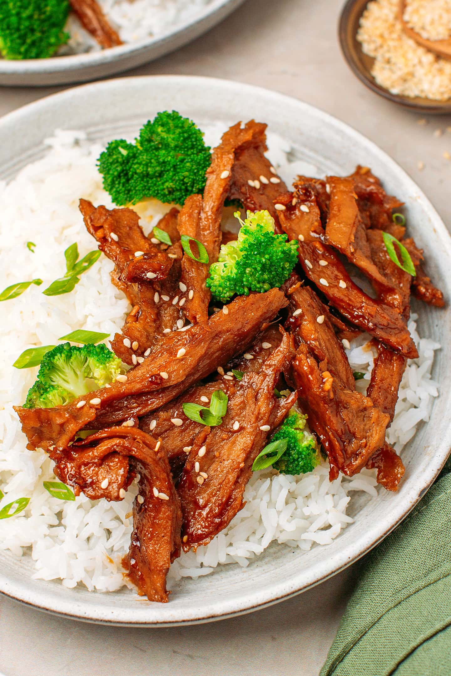 Close-up of vegan teriyaki chicken strips over a bed of white rice.