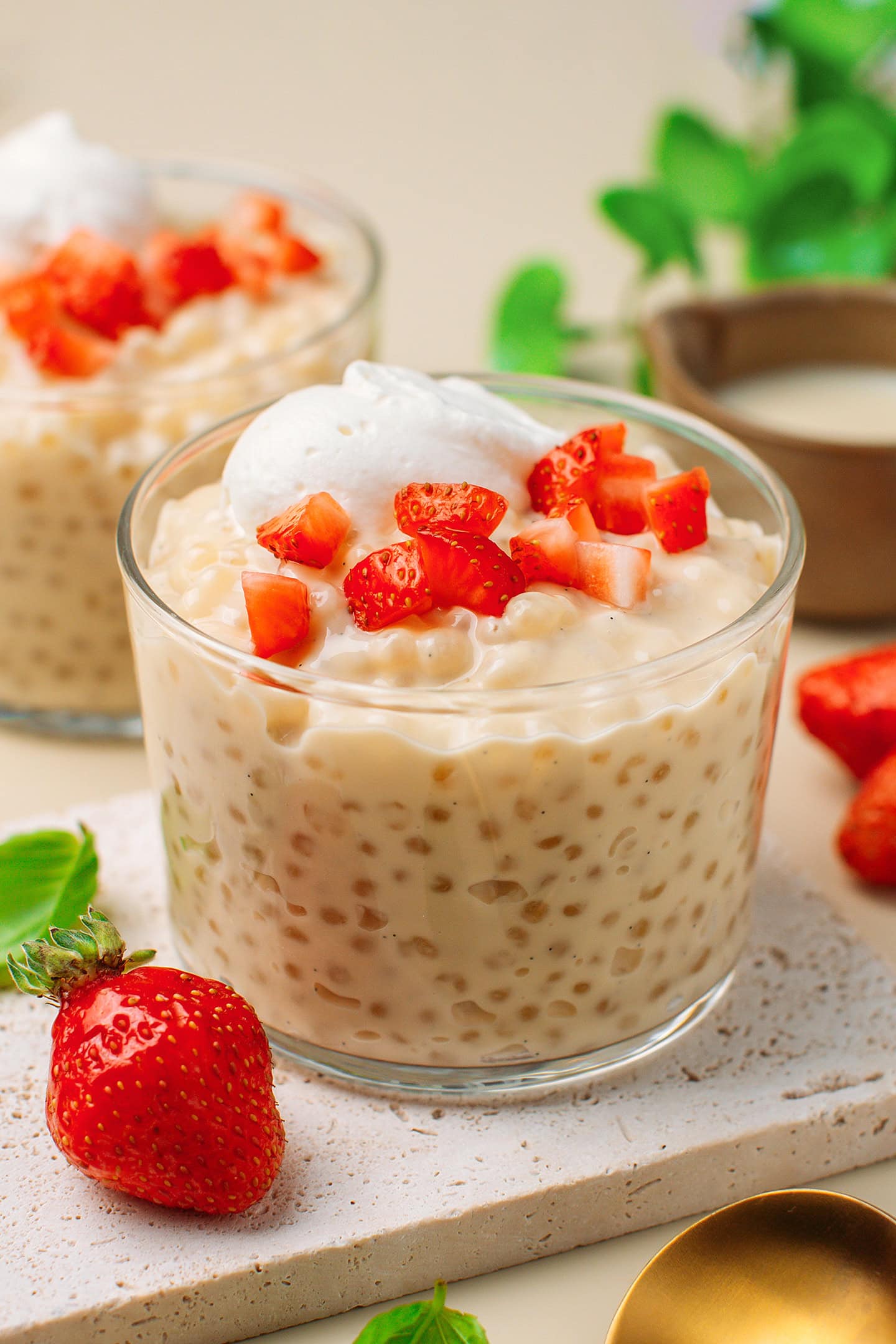 Ramekin filled with vanilla tapioca pudding and topped with chopped strawberries.