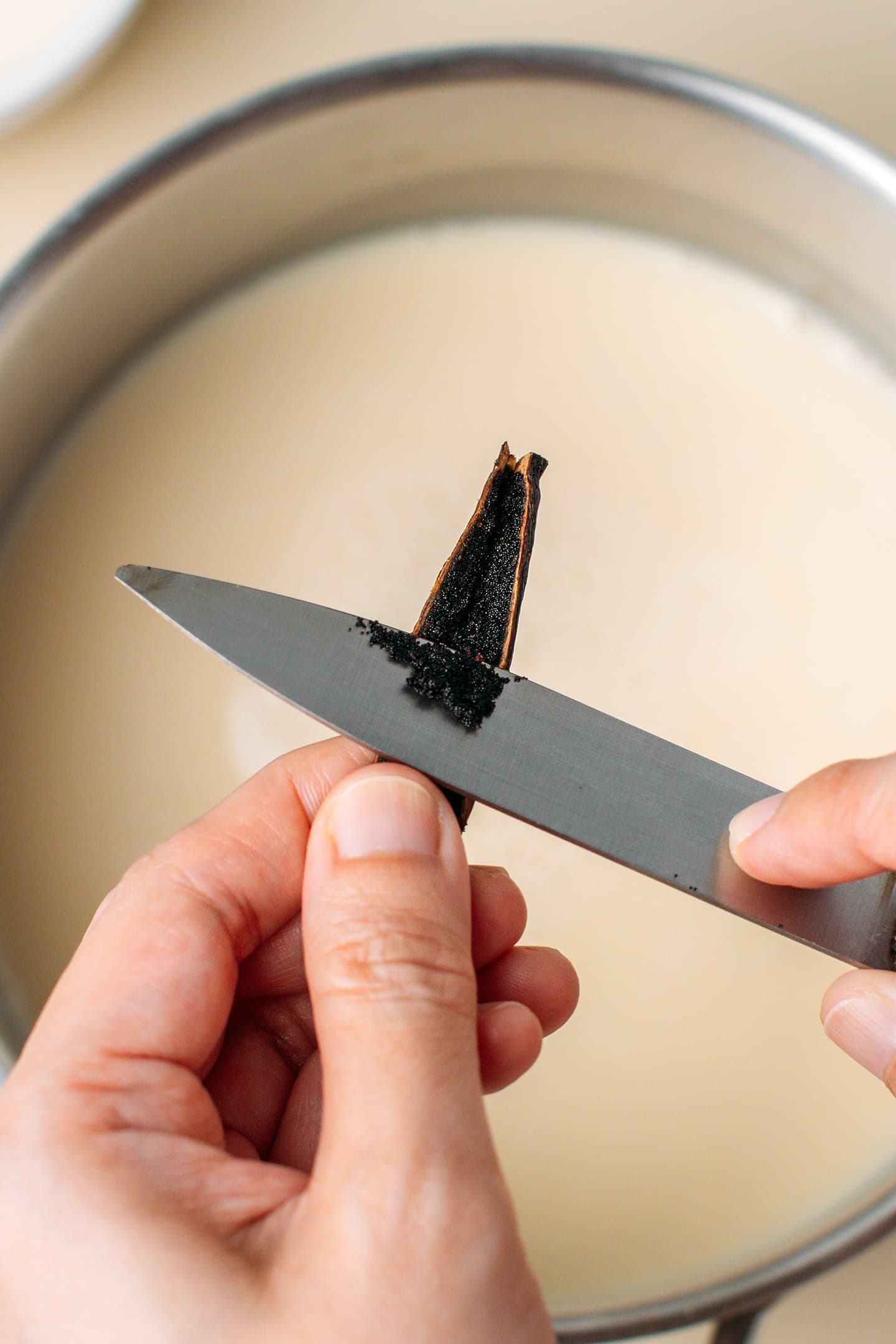 Scraping the seeds out of a vanilla bean.
