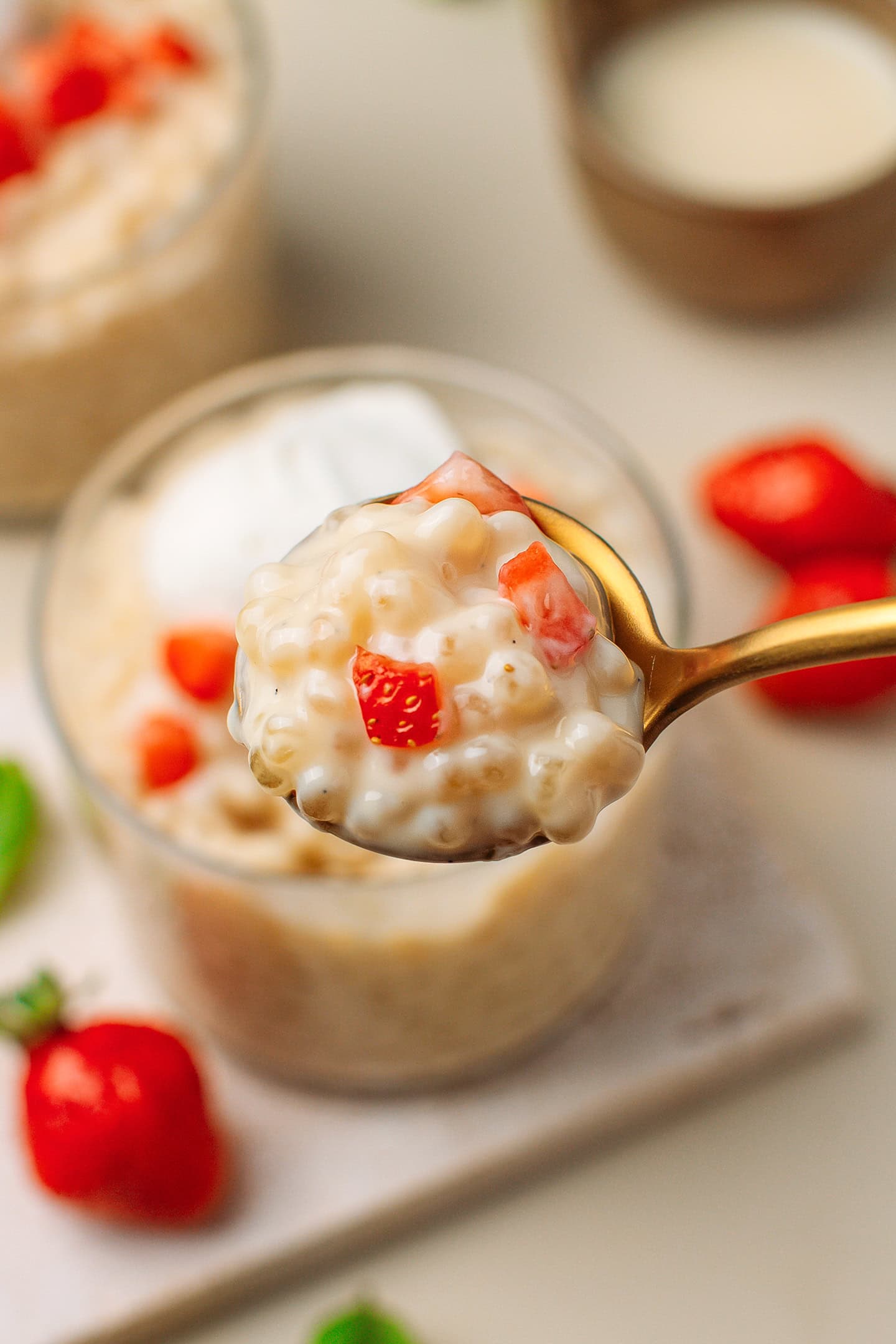 Spoonful of tapioca pudding with chopped strawberries.