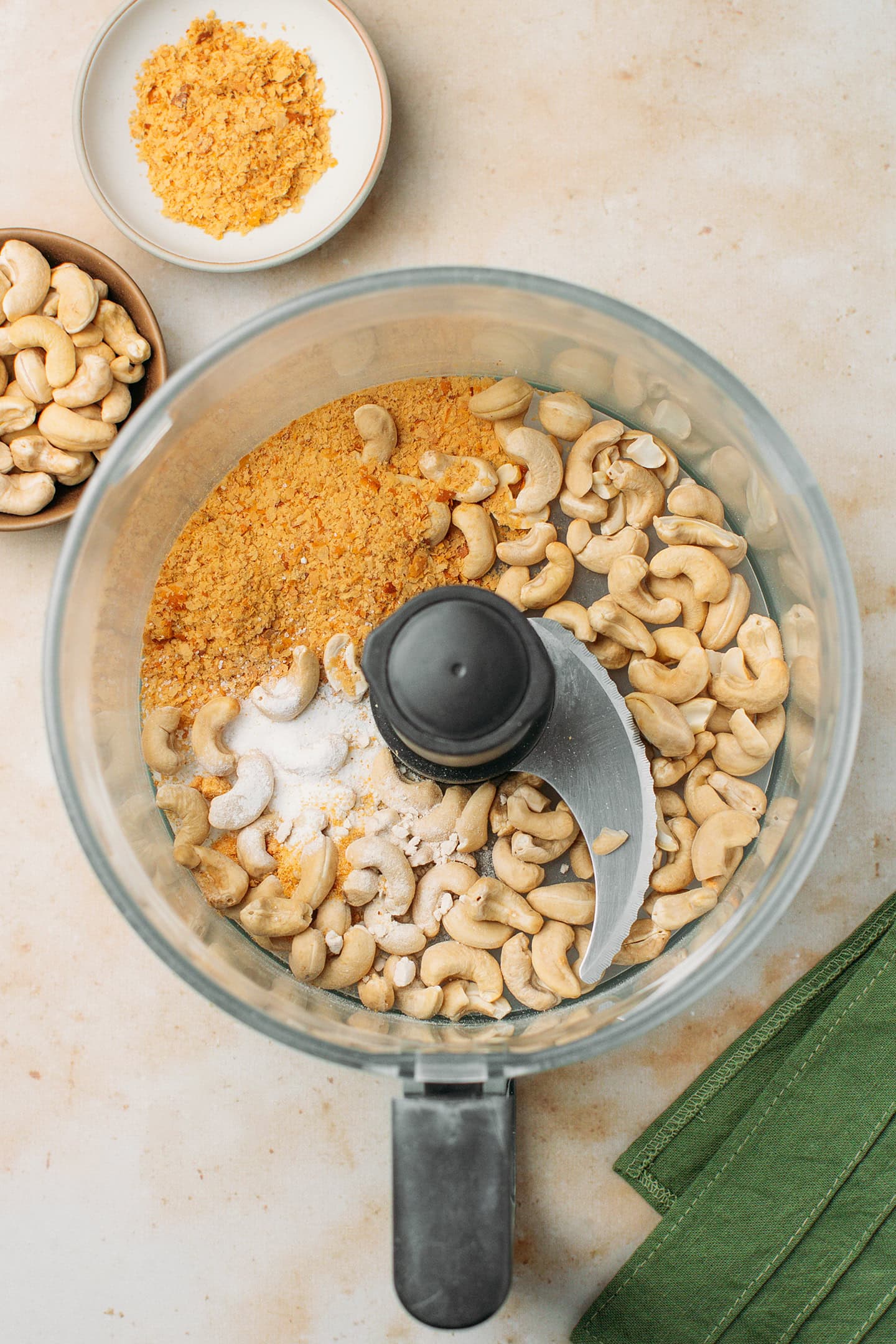 Raw cashews, nutritional yeast, and salt in a food processor.
