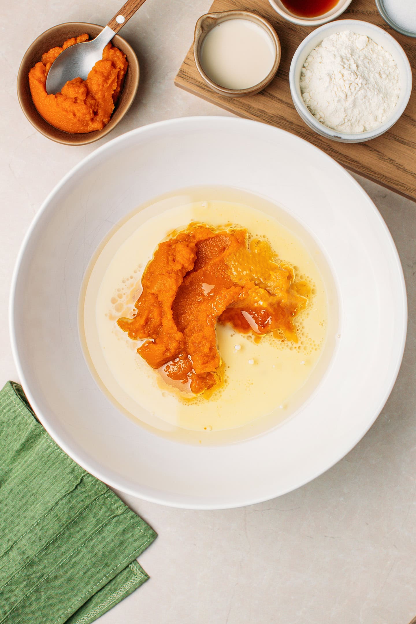 Pumpkin purée, oil, and milk in a mixing bowl.